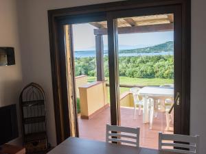 ein Esszimmer mit Blick auf einen Tisch und Stühle in der Unterkunft Residence Cala Petralana in Porto Pollo