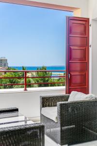 een woonkamer met een rode deur en rieten stoelen bij Limassol Marina Nereids D22 by Ezoria Villas in Limassol