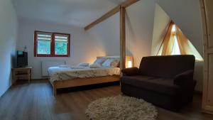 ソバタにあるCasa Cameliaのベッドとソファと椅子のある寝室