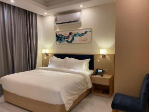 a hotel room with a bed and a chair at Season Inn Hotel Apartment_Duqm in Duqm