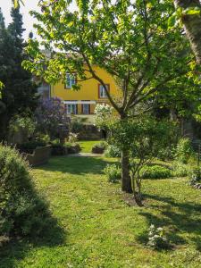 einen Garten mit einem gelben Haus im Hintergrund in der Unterkunft La Voie Du Viaur in Tanus