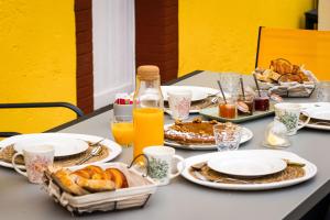 einen Tisch mit Teller mit Speisen und Orangensaft in der Unterkunft La Voie Du Viaur in Tanus
