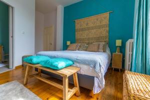 Schlafzimmer mit einem Bett mit blauer Wand in der Unterkunft La Voie Du Viaur in Tanus