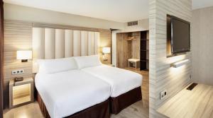 Tempat tidur dalam kamar di Gran Hotel Luna de Granada