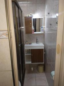a bathroom with a sink and a shower at 100 mts Praia Ar Condicionado Wi-Fi 600 Roupa Cama Toalha 24 hs in Santos