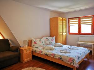 een kleine slaapkamer met een bed en een bank bij Casa Camelia in Sovata