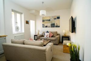 a living room with two couches and a tv at 'The Retreat' - Stylish one bedroom apartment in Holt, Norfolk in Holt