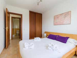 a bedroom with a white bed with towels on it at HomeForGuest Apartamento con Piscina en Caleta de Fuste in Caleta De Fuste +21 photos