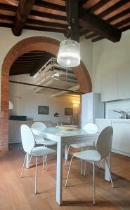 Un comedor con una mesa y sillas blancas. en MattiMamiHouse, en Montepescali
