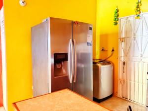 d'une cuisine avec un réfrigérateur en acier inoxydable dans un mur jaune. dans l'établissement Sensational 2 Bedroom Getaway in Florence Hall, à The Rock