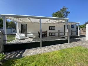 a deck with a pergola on a house at Beach Resort Kamperland - 1653 in Kamperland