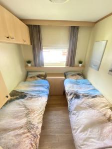 two beds in a small room with a window at Beach Resort Kamperland - 1653 in Kamperland