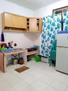 Il comprend une petite cuisine équipée d'une table et d'un réfrigérateur. dans l'établissement Villa Bukit Asri Untuk 1 Kamar Berastagi View, à Berastagi