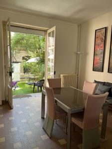 comedor con mesa de cristal y sillas en Maison de la Huardière en Sully-sur-Loire