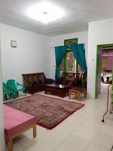 sala de estar con sofá y alfombra en Villa Bukit Asri Untuk 1 Kamar Berastagi View, en Berastagi