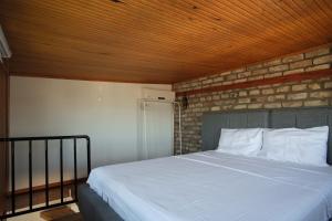 Un dormitorio con una cama blanca con una pared de ladrillo. en Sunflower Apartments, en Estambul