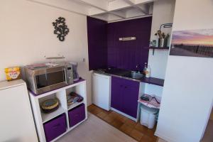 a kitchen with purple cabinets and a microwave at Appartement Seignosse le Penon/plage in Seignosse
