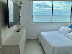 a bedroom with a bed and a large window at apartamento en bocagrande in Cartagena de Indias