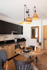 a kitchen with a wooden table and black cabinets at TERRESENS - L'ETENDARD in Vaujany