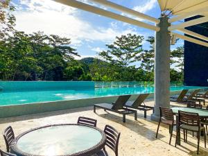 een patio met een tafel en stoelen en een zwembad bij Summit Rainforest Golf Resort & All Inclusive in Paraíso