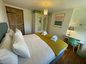 a bedroom with a bed with two towels on it at Redlands Cottage Surrey Hills in Dorking