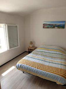 una camera bianca con un letto e una finestra di Appartement 62 m2 1er etage avec jardin au rdc a Saint-Génis