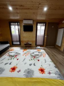 ein großes Bett mit Blumen auf einem Zimmer in der Unterkunft Magic Box in Constanţa