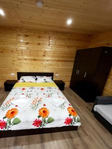 a bedroom with a bed with a floral bedspread at Magic Box in Constanţa