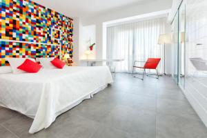 ein Schlafzimmer mit einem großen Bett und einer farbenfrohen Wand in der Unterkunft Hotel Villamor in Denia