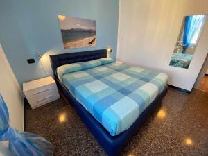 um quarto com uma cama com um cobertor xadrez azul em Apartament Arcobaleno a 500 metri dal mare em Albissola Marina