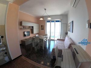 a living room with a table and a dining room at Apartament Arcobaleno a 500 metri dal mare in Albissola Marina