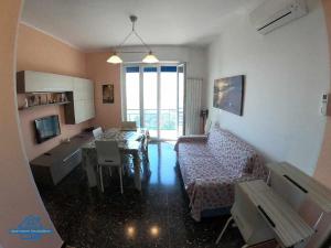 a living room with a couch and a table at Apartament Arcobaleno a 500 metri dal mare in Albissola Marina