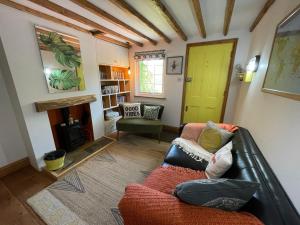 a living room with a couch and a fireplace at Redlands Cottage Surrey Hills in Dorking