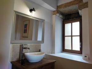 a bathroom with a sink and a mirror and a window at Planches et Plonk in Belvès