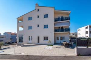 a large white building with a patio in front of it at Villa Aurelia in Zadar