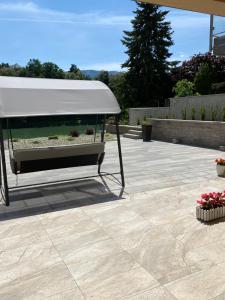 a patio with a white umbrella and some flowers at Maximo Apartments - free parking in Maribor