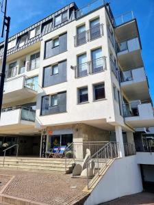 a tall white building with a staircase in front of it at Stella Baltic 26 in Świnoujście