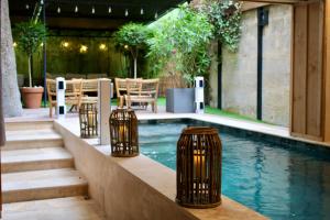a swimming pool with three trash cans next to it at Le Boutique Hotel & Spa in Bordeaux