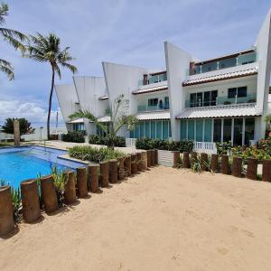 a building on the beach with a swimming pool at Maria Farinha Residence Prince - LocarHouse in Paulista