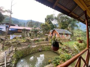 a view from a balcony of a house with a pond at Odyssey Stays Darap in Pelling