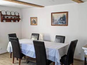 a dining room with a white table and chairs at Chalupa u rybníka Střehom in Dolní Bousov