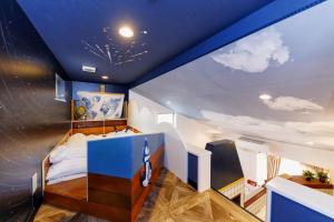 a bedroom with a blue ceiling with clouds on it at Holy Town in Tokyo