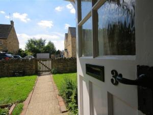 a white door with a view of a yard at Noel Cottage in Chipping Campden