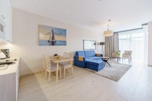 salon z niebieską kanapą i stołem w obiekcie Apartament z aneksem kuchennym i basenem 426 Diune Hotel Resort w Kołobrzegu