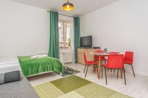 uma sala de estar com uma mesa e cadeiras vermelhas em Apartament Starogdański 21 em Gdansk