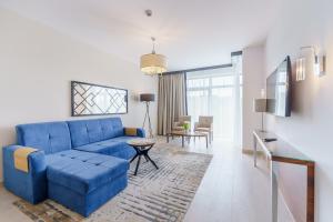 salon z niebieską kanapą i stołem w obiekcie Apartament z aneksem kuchennym i basenem 426 Diune Hotel Resort w Kołobrzegu