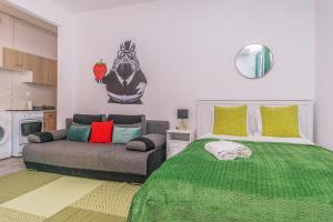 a bedroom with a green bed and a couch at Apartament Starogdański 21 in Gdańsk