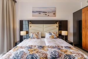 sypialnia z dużym łóżkiem i dwiema lampami w obiekcie Apartament z aneksem kuchennym i basenem 426 Diune Hotel Resort w Kołobrzegu +30 zdjęć