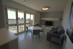 a kitchen and living room with a table and a couch at Lignano Pineta with sea view in Lignano Sabbiadoro