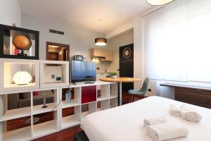 a room with a bed and a tv and a table at PrimoPiano - Gargano in Milan